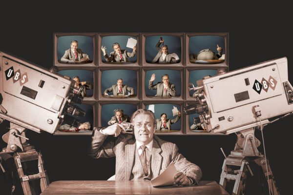 Alexander Rossi als Howard Beale in „Network“ an einem Schreibtisch, links und rechts Kameras. Er hält sich eine Pistole an den Kopf. © Bettina Frenzel